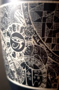 Réalisation d'un verre en céramique gravé avec des motifs ésotériques.