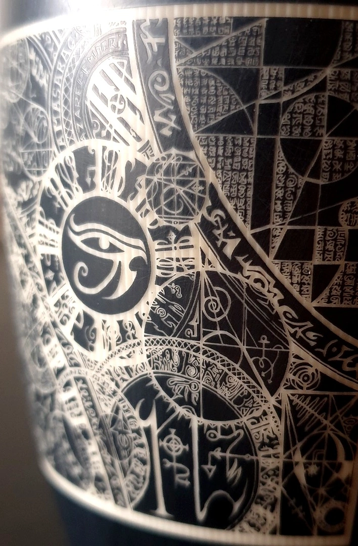 Réalisation d'un verre en céramique gravé avec des motifs ésotériques.