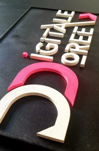 Réalisation d'une enseigne pour le studio Digitale Doree, avec des couleurs noire, rose et blanche.